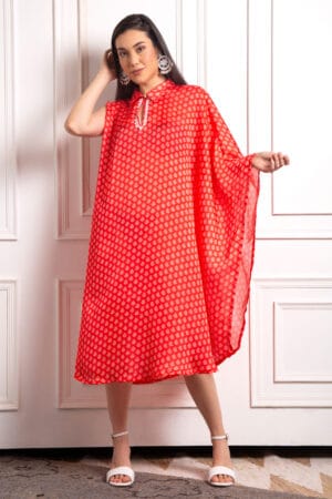 The kaftan is adorned with delicate white moti (pearls), meticulously hand-stitched to create intricate patterns that enhance its vibrant red hue.